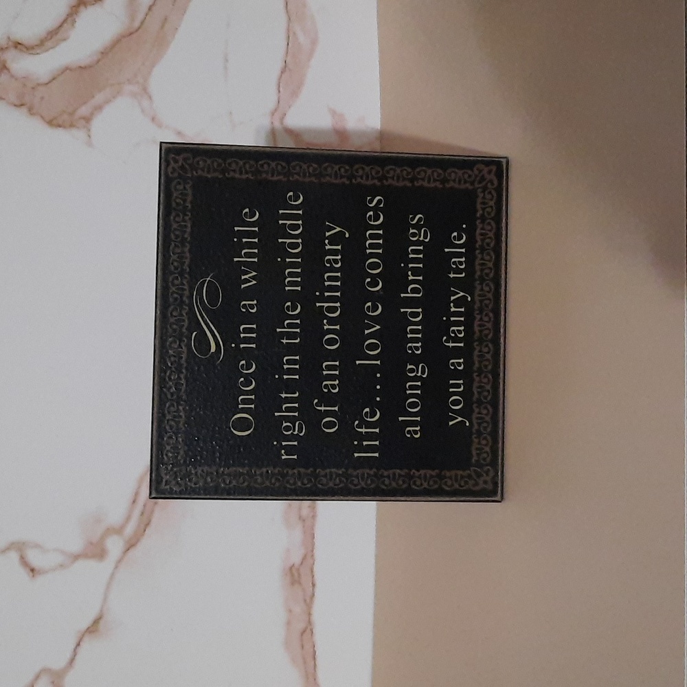 "Love comes along and brings you a fairytale," inspirational black wall plaque.